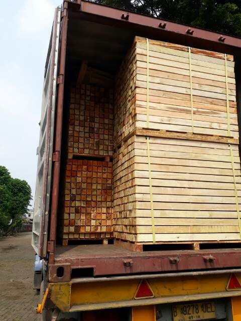 Loading finished timber onto truck for export